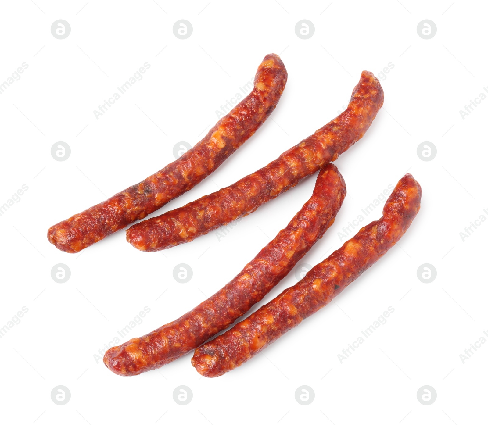 Photo of Many thin dry cured sausages isolated on white, top view