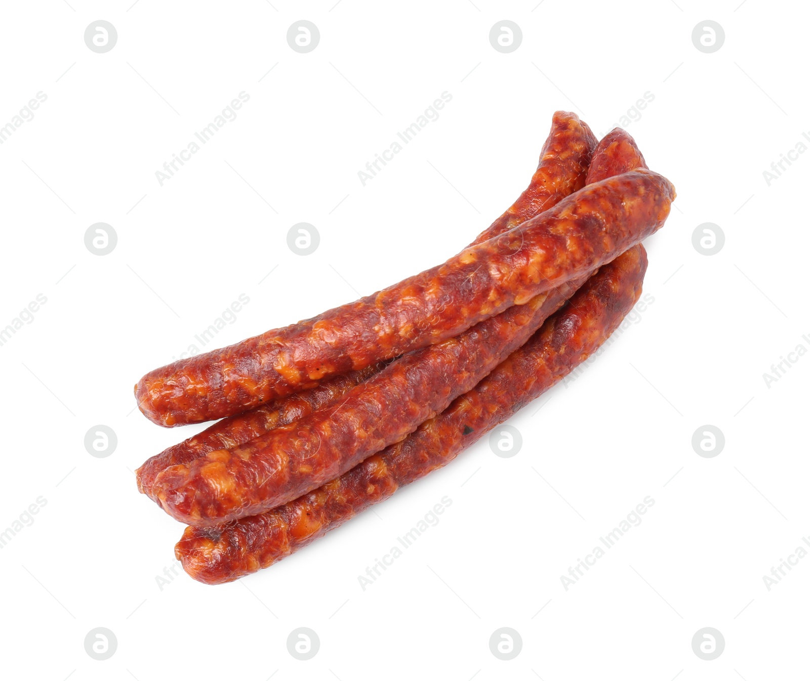 Photo of Many thin dry cured sausages isolated on white, top view