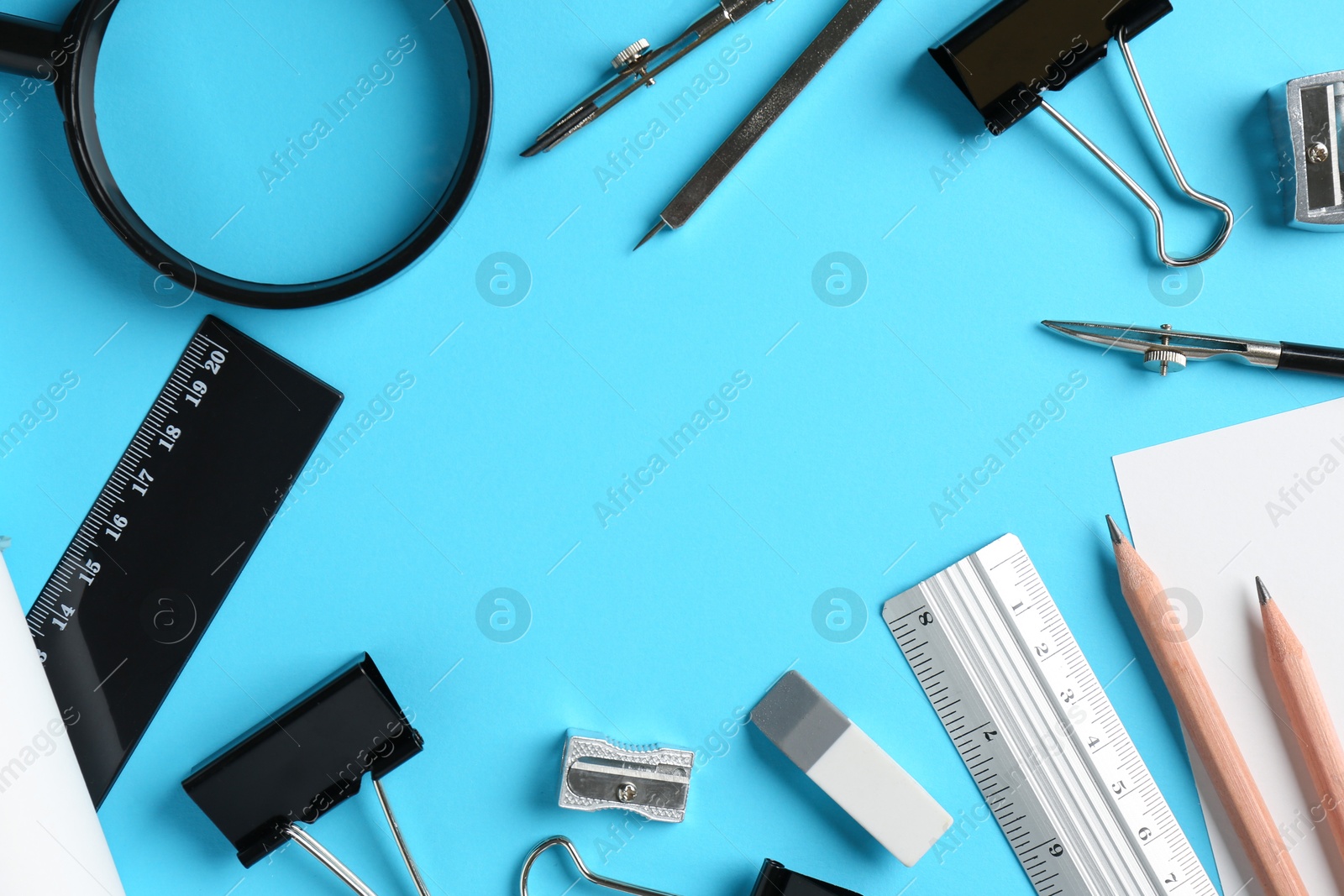 Photo of Flat lay composition with ruler and other stationery on light blue background, space for text