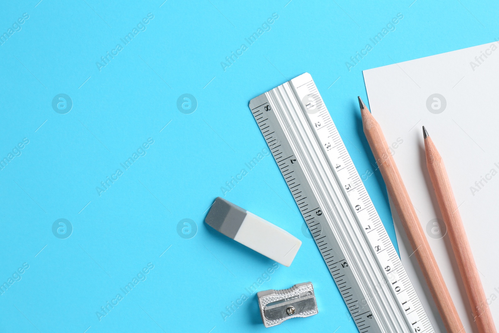 Photo of Flat lay composition with ruler and other stationery on light blue background, space for text