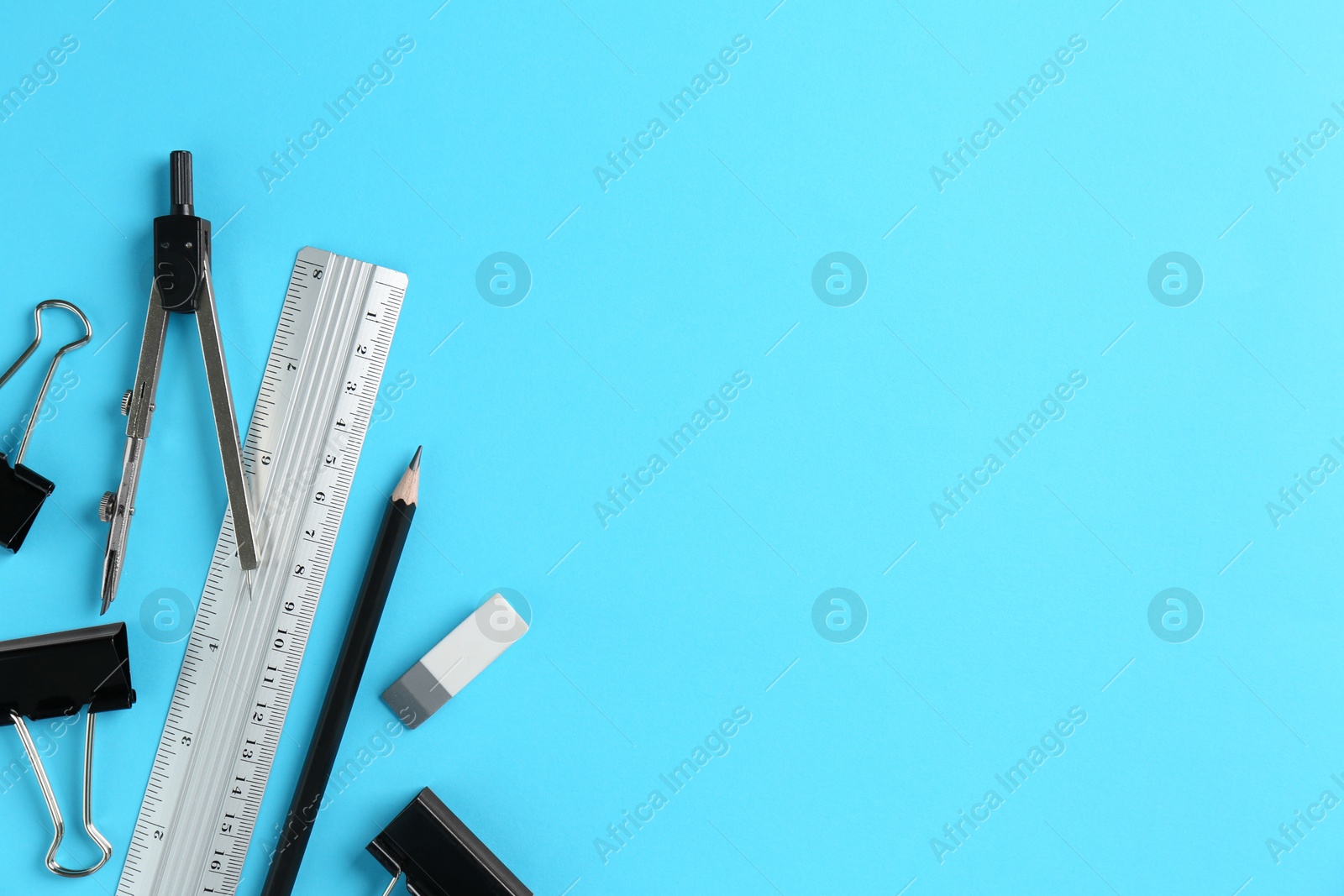 Photo of Flat lay composition with ruler and other stationery on light blue background, space for text