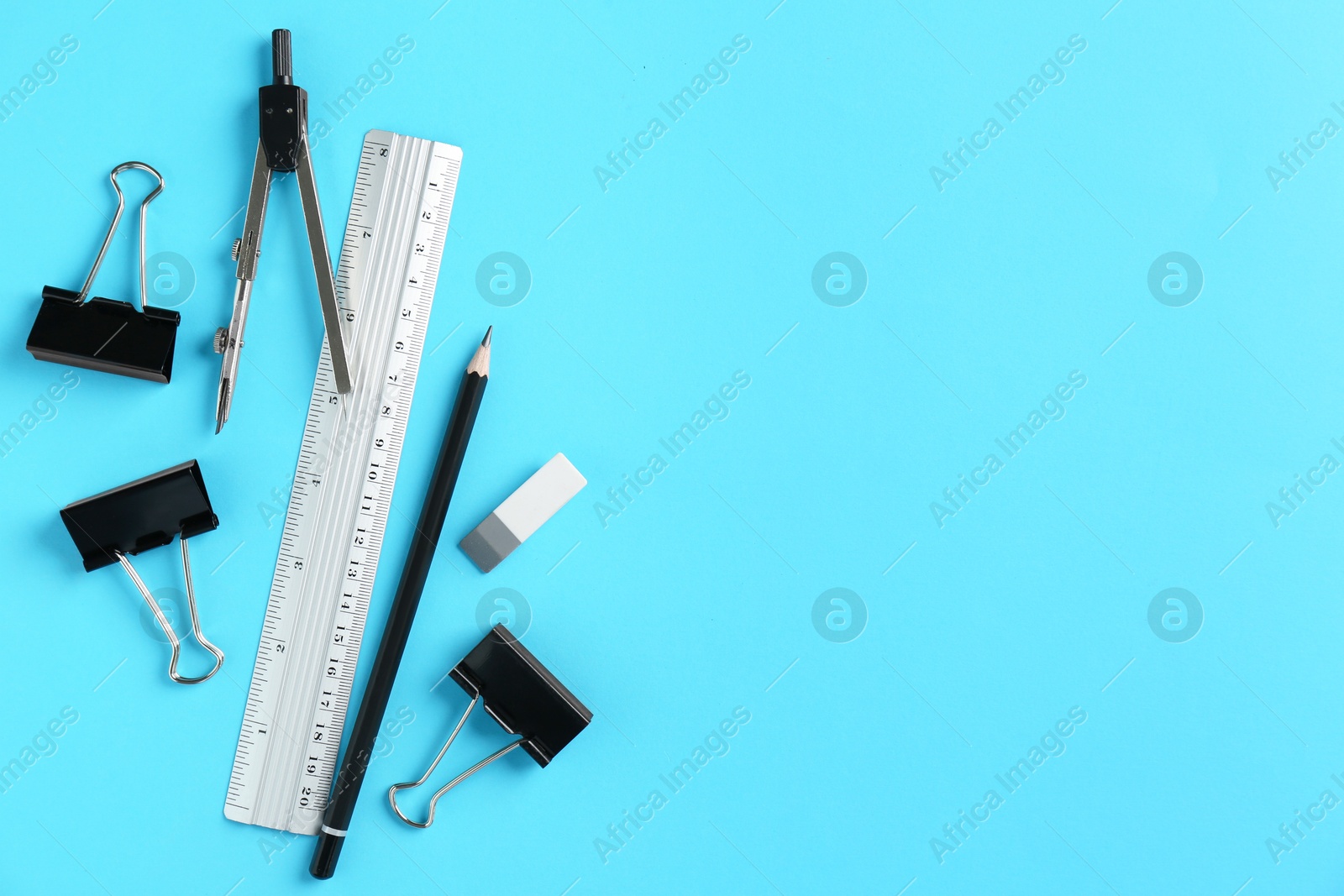 Photo of Flat lay composition with ruler and other stationery on light blue background, space for text