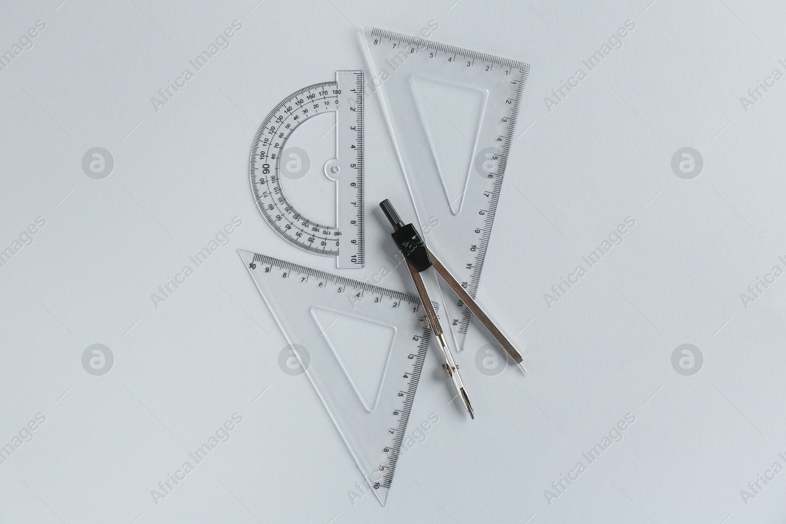 Photo of Rulers and compass on light grey background, flat lay