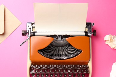 Photo of Vintage typewriter with sheet of paper and envelope on pink background, flat lay