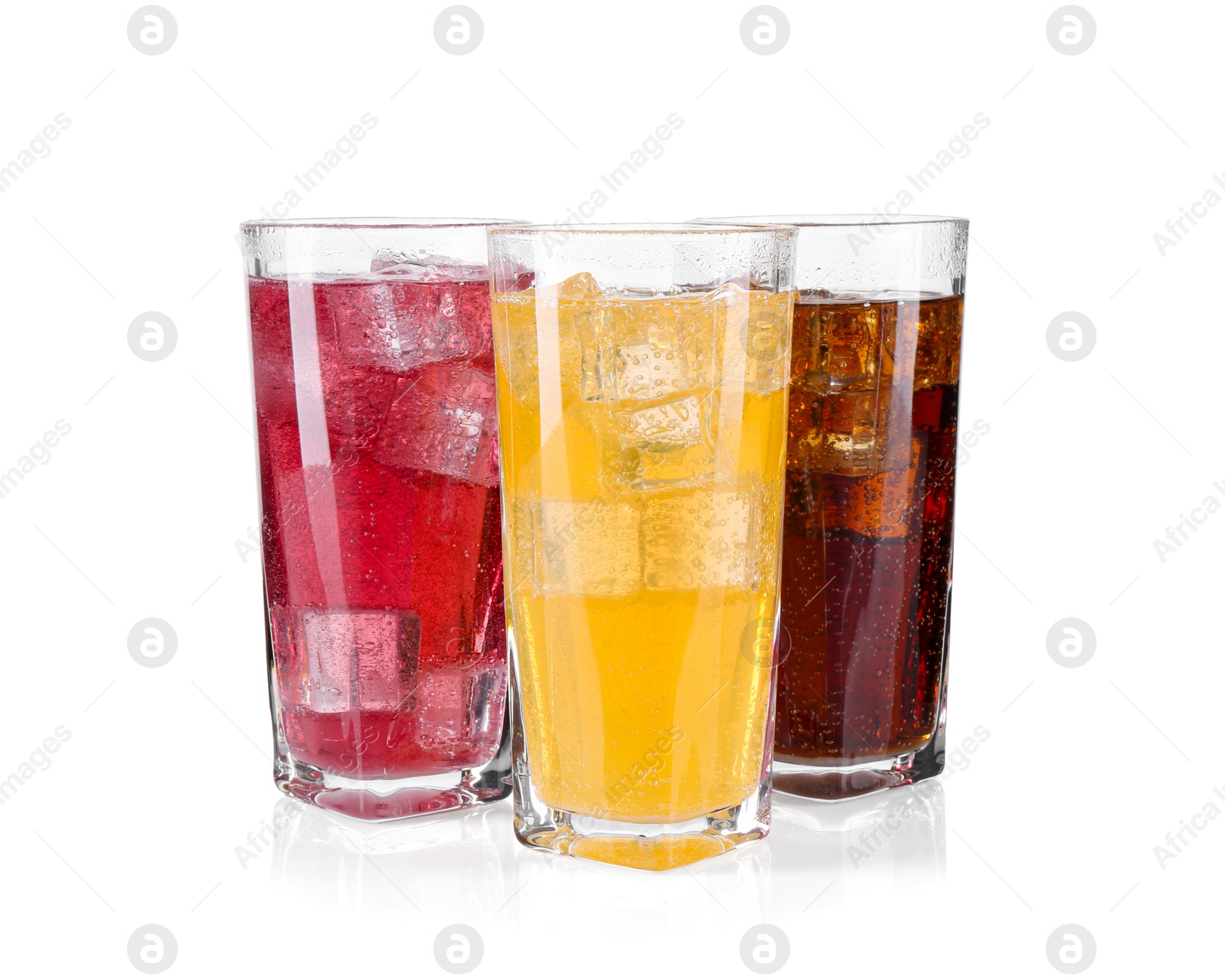 Photo of Soda water of different flavors with ice cubes in glasses isolated on white