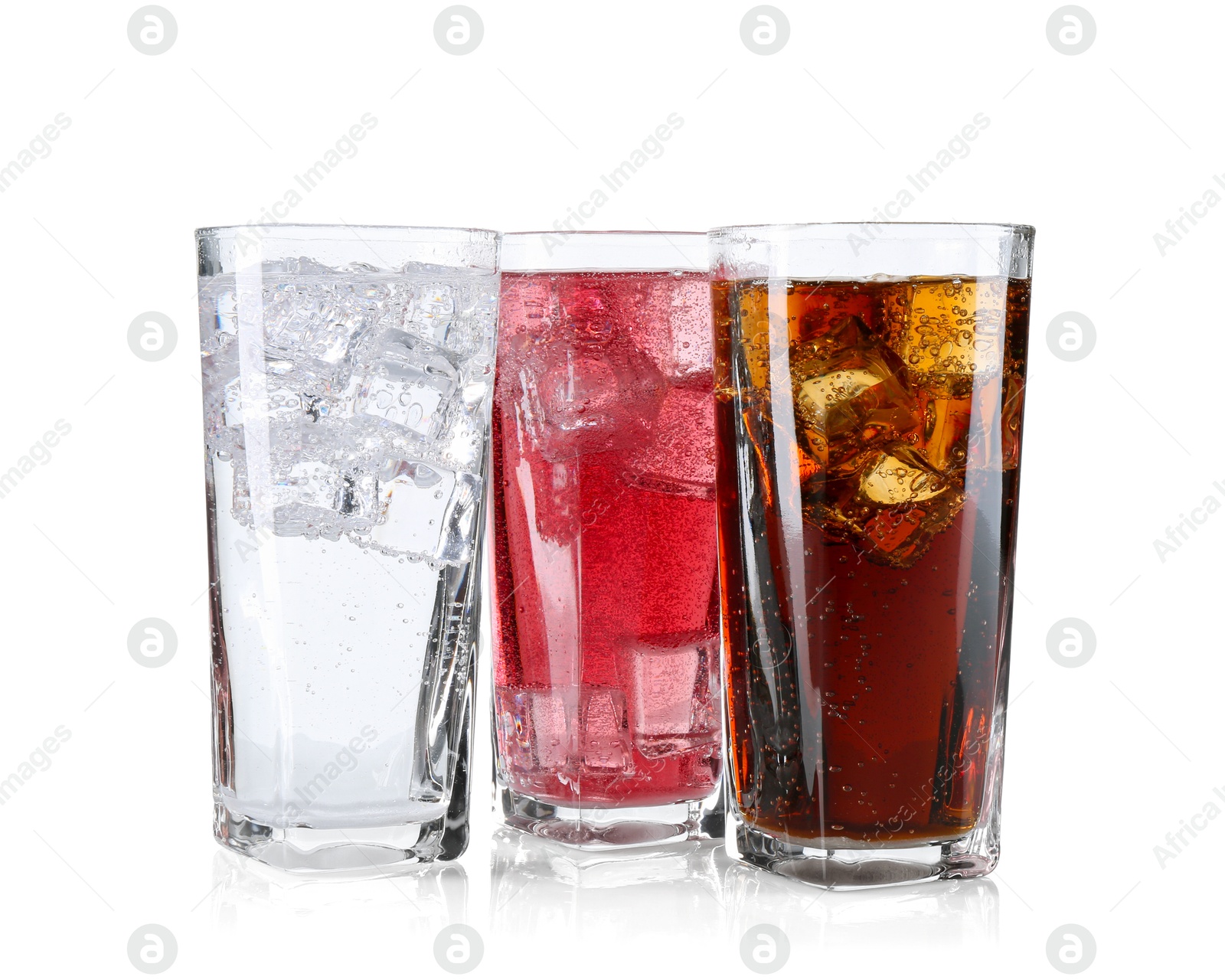 Photo of Soda water of different flavors with ice cubes in glasses isolated on white