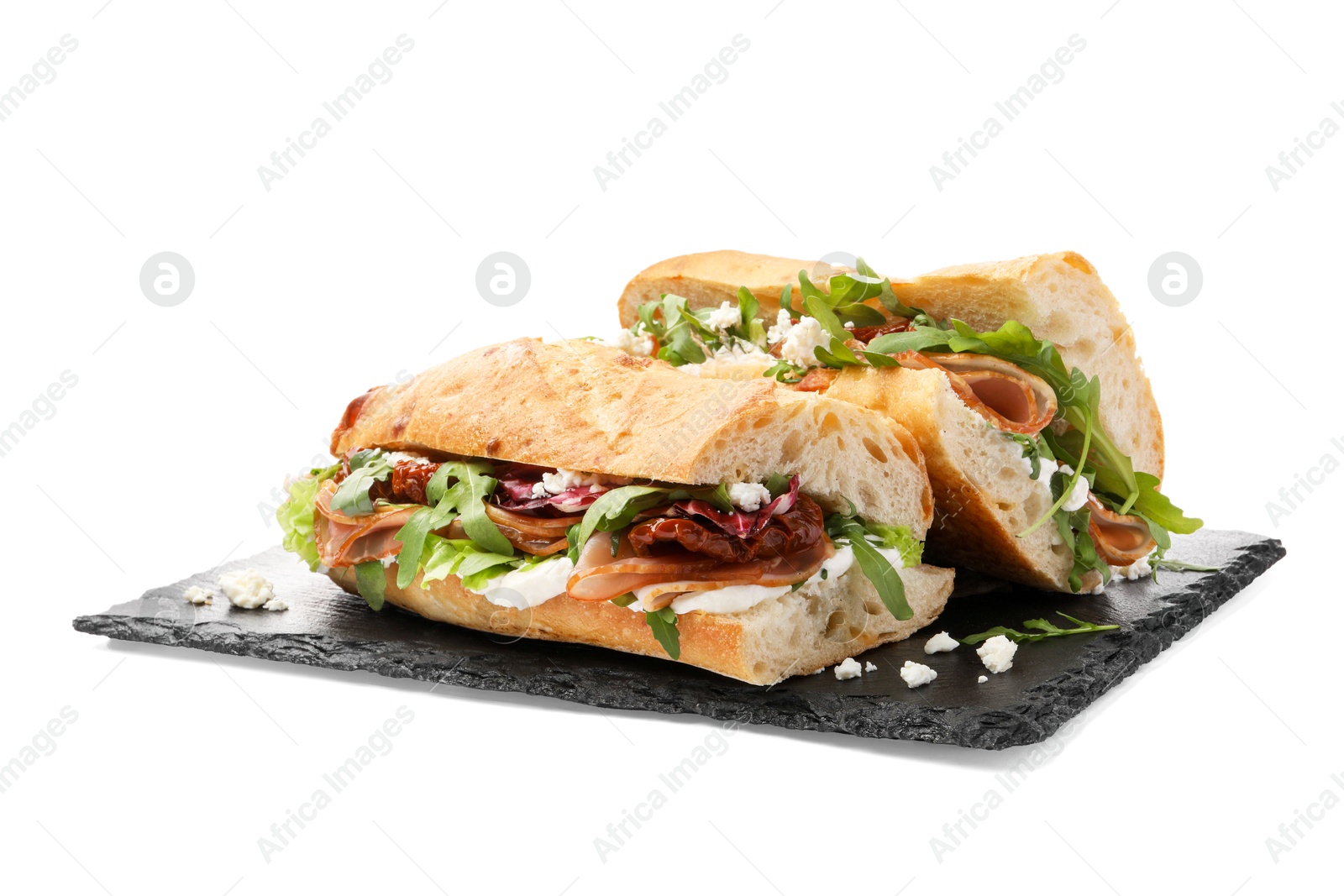 Photo of Halves of baguette sandwich with prosciutto and sun dried tomatoes isolated on white