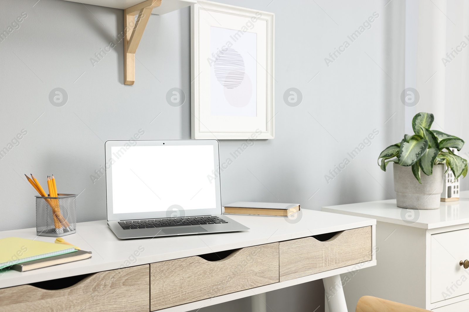 Photo of Comfortable workplace with modern laptop on white table indoors