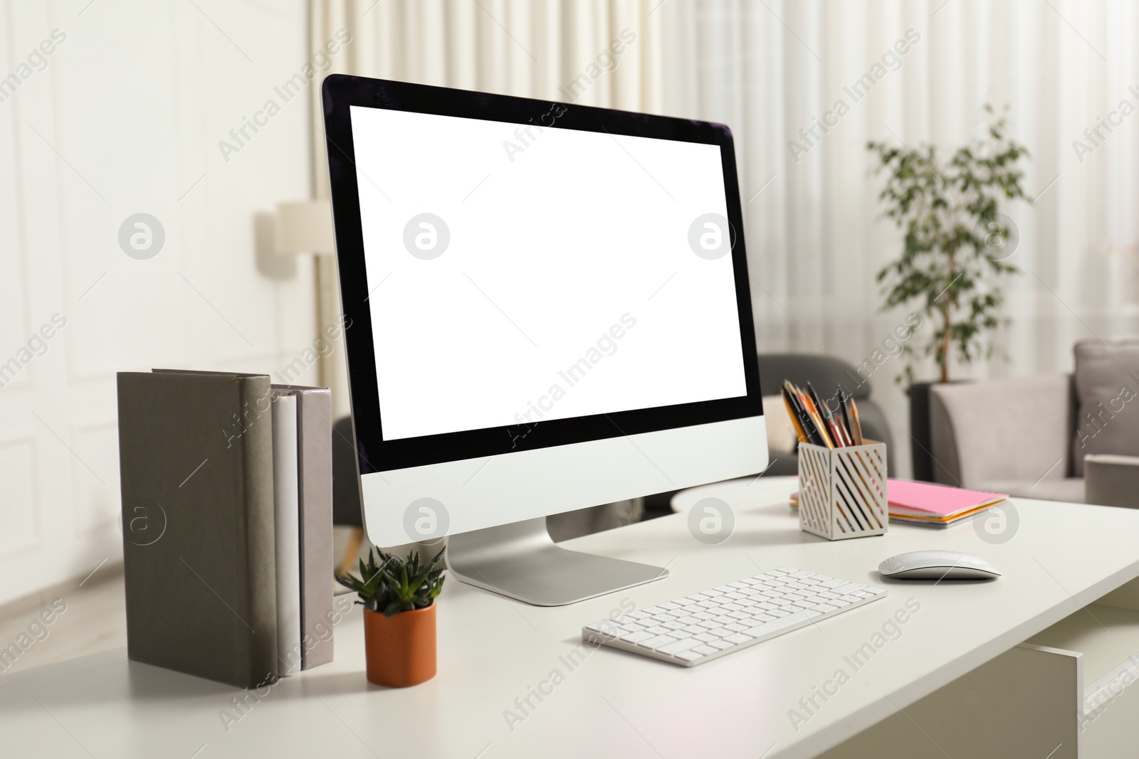 Photo of Modern workplace with computer and stationery on white desk indoors