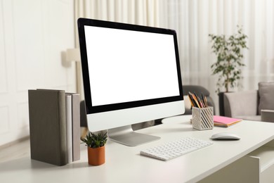 Photo of Modern workplace with computer and stationery on white desk indoors