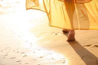 Photo of Young  woman walking on beach, closeup view