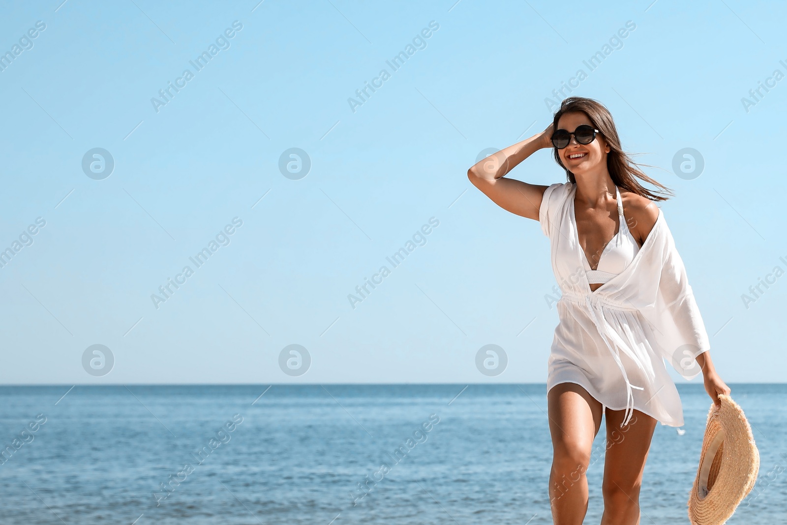 Photo of Young woman with beautiful body on beach. Space for text