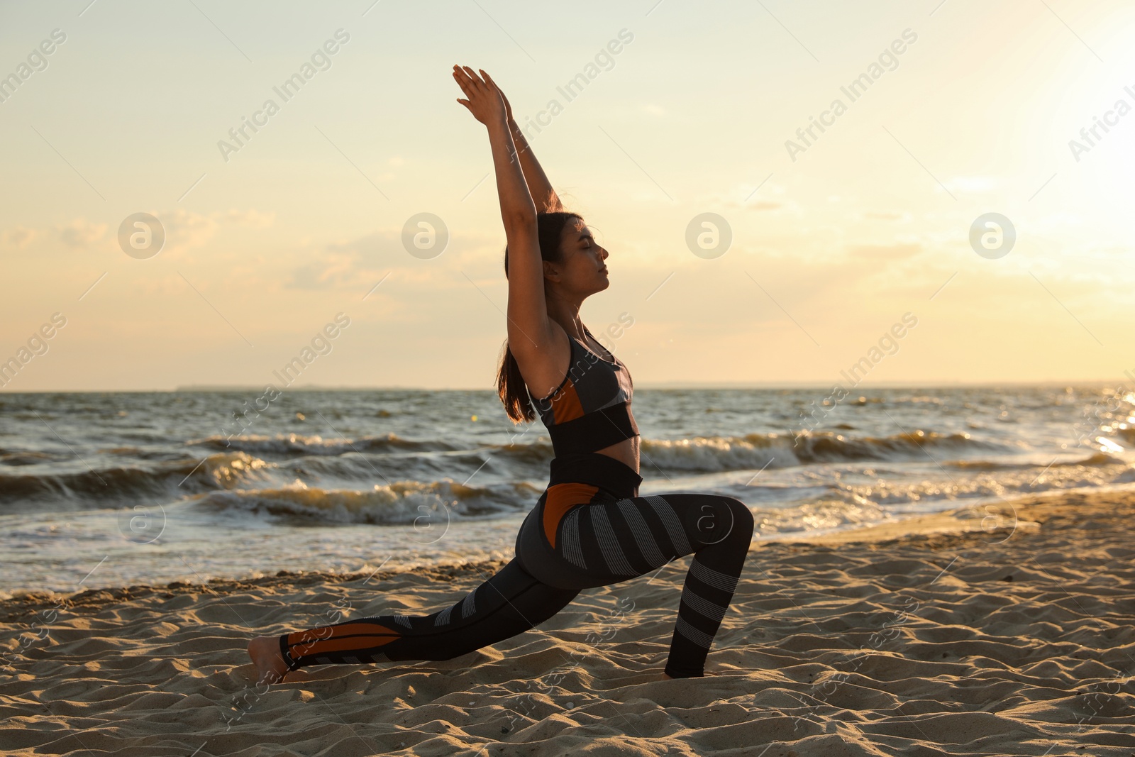 Photo of Young girl with slim body doing yoga on beach