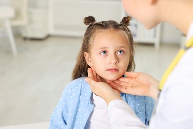 Photo of Doctor examining girl's throat in clinic during appointment