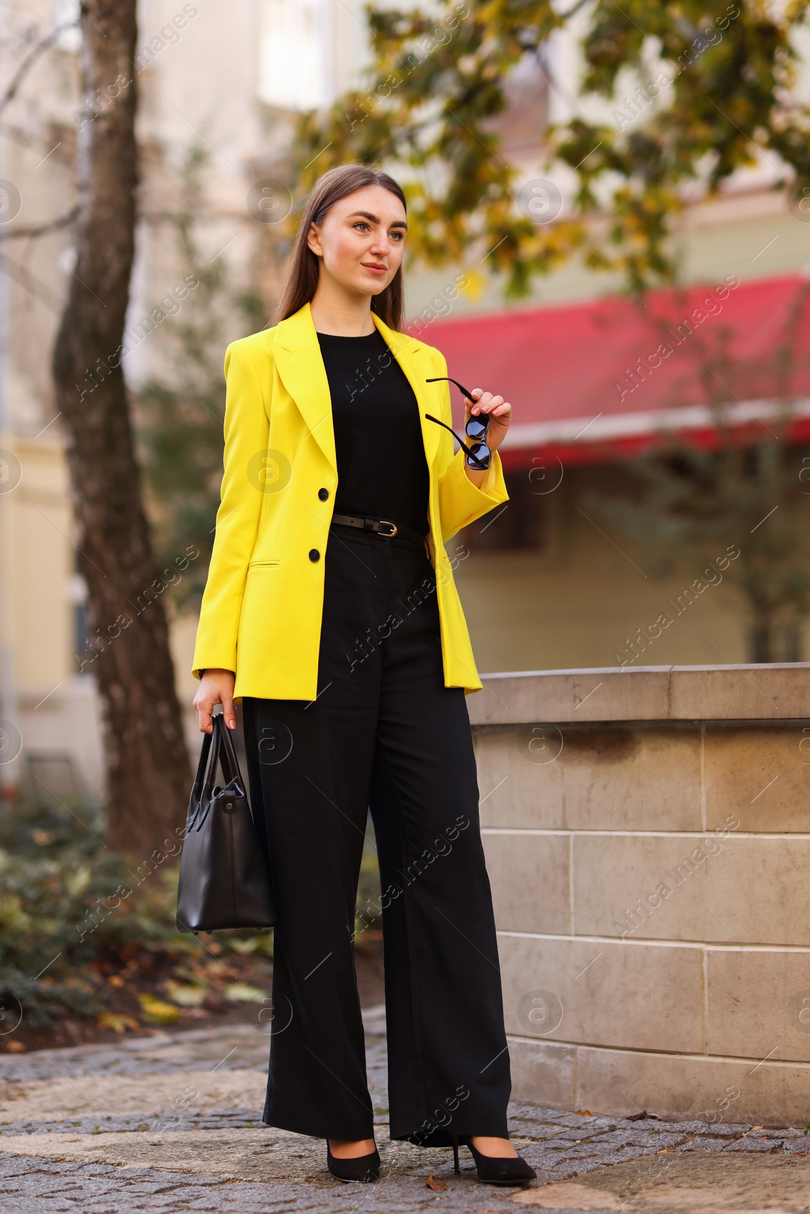 Photo of Beautiful businesswoman in stylish suit on city street