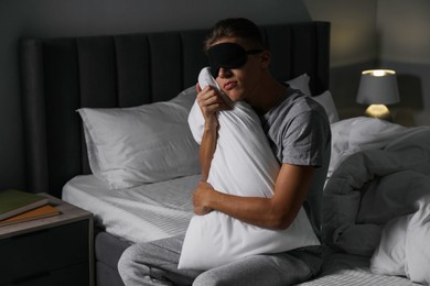 Photo of Young man suffering from sleepwalking on bed at home