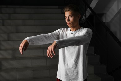 Photo of Young man suffering from sleepwalking on stairs indoors