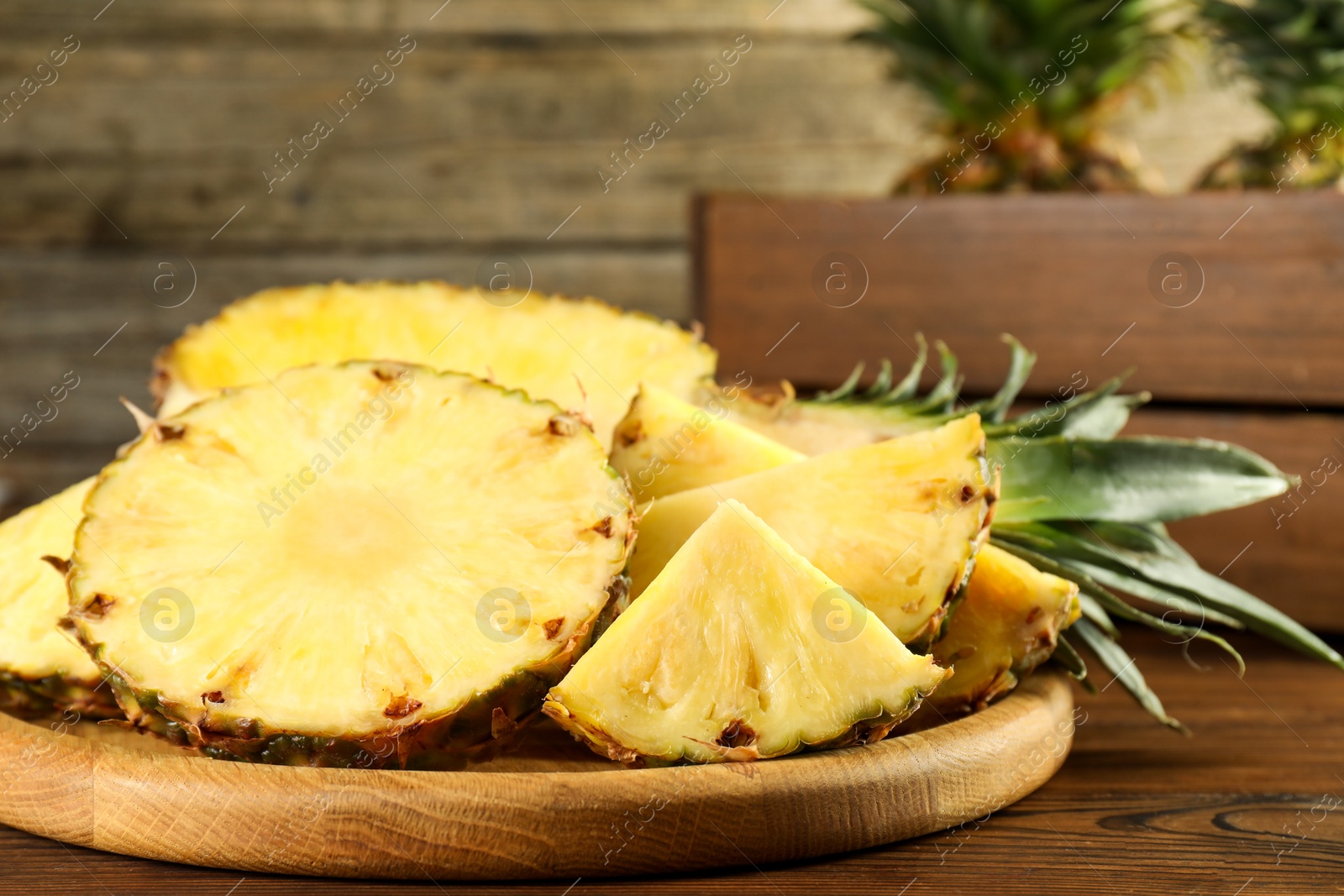 Photo of Cut fresh ripe pineapple on wooden table, closeup