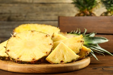 Photo of Cut fresh ripe pineapple on wooden table, closeup