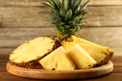 Photo of Cut fresh ripe pineapple on wooden table, closeup