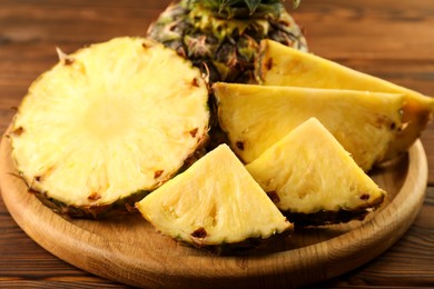 Photo of Cut fresh ripe pineapple on wooden table, closeup