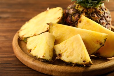 Photo of Cut fresh ripe pineapple on wooden table, closeup