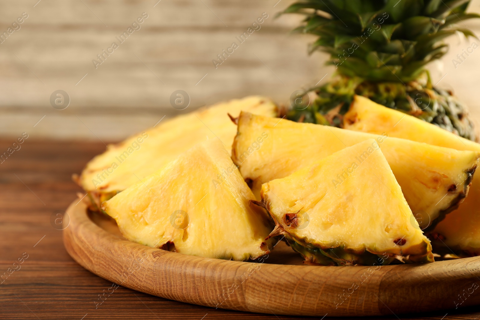 Photo of Cut fresh ripe pineapple on wooden table, closeup