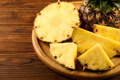 Photo of Cut fresh ripe pineapple on wooden table, closeup