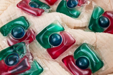 Photo of Laundry detergent capsules on beige fabric, closeup