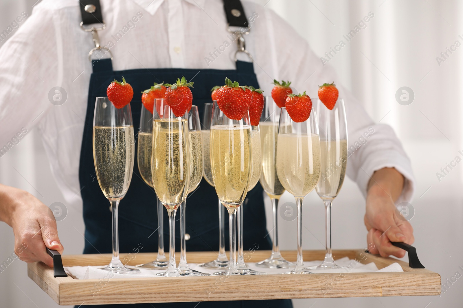 Photo of Waiter holding tray with glasses of champagne indoors, closeup