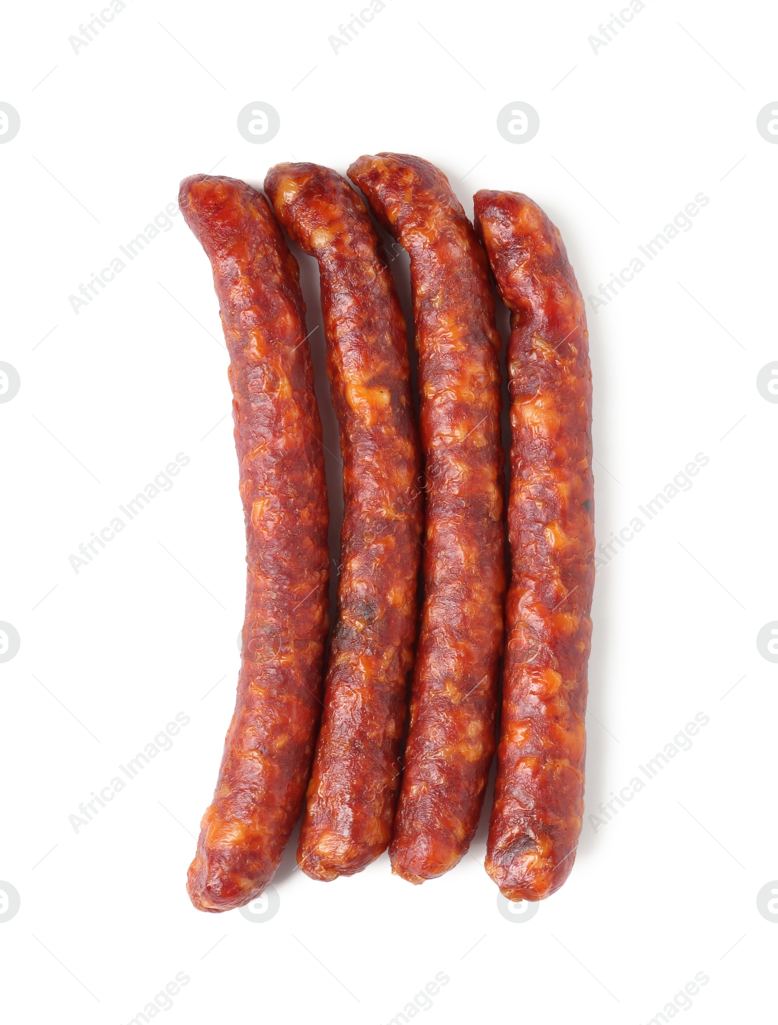 Photo of Many thin dry cured sausages isolated on white, top view