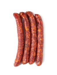 Photo of Many thin dry cured sausages isolated on white, top view