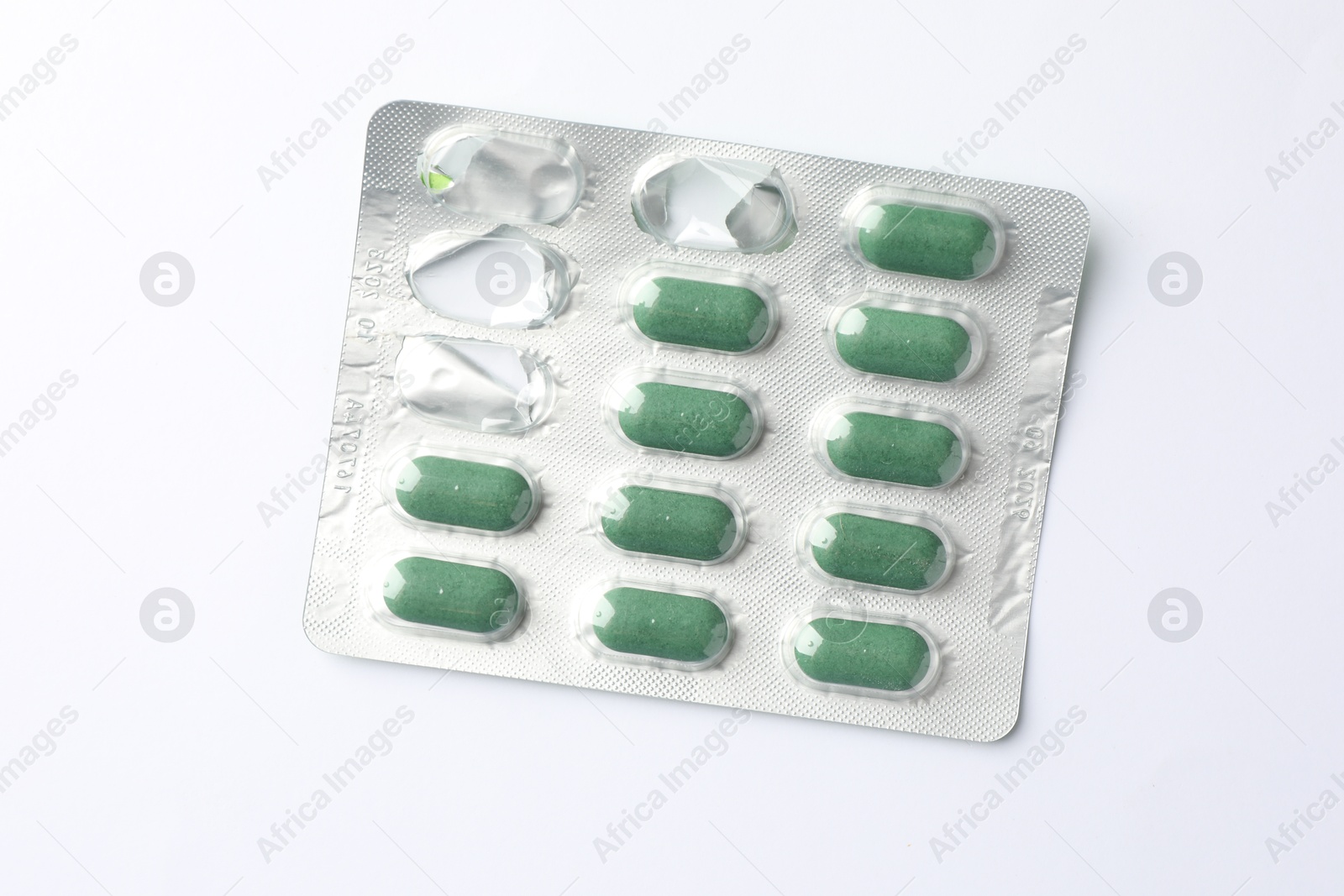 Photo of Blister with green pills on white background, top view