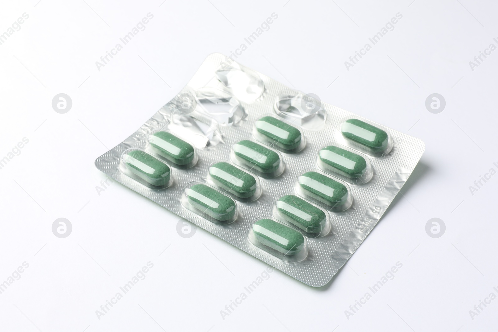 Photo of Blister with green pills on white background