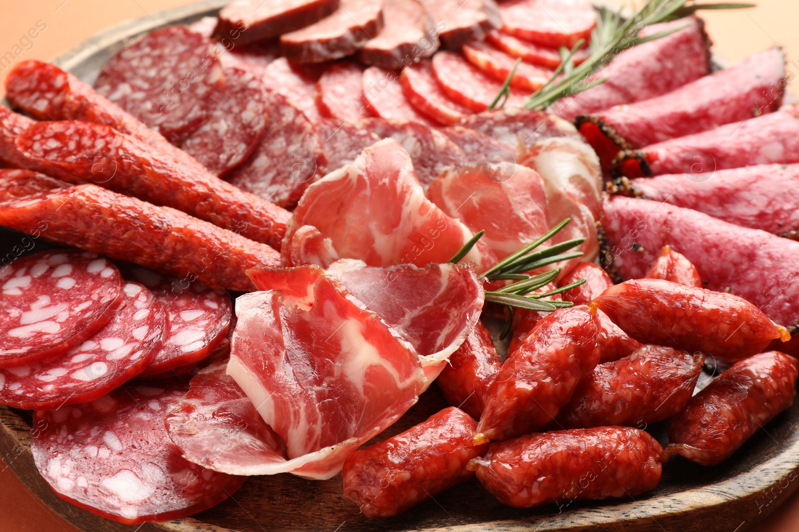 Photo of Different smoked sausages slices on orange background, closeup