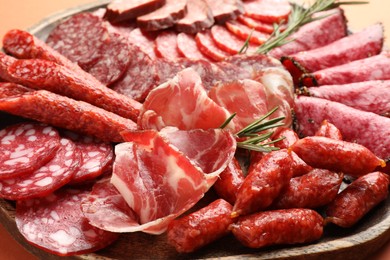 Photo of Different smoked sausages slices on orange background, closeup