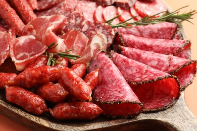 Photo of Different smoked sausages slices on orange background, closeup