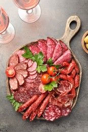 Photo of Different smoked sausages slices served on grey table, flat lay