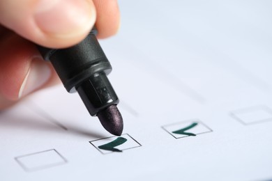 Photo of Woman checking box of paper form, closeup