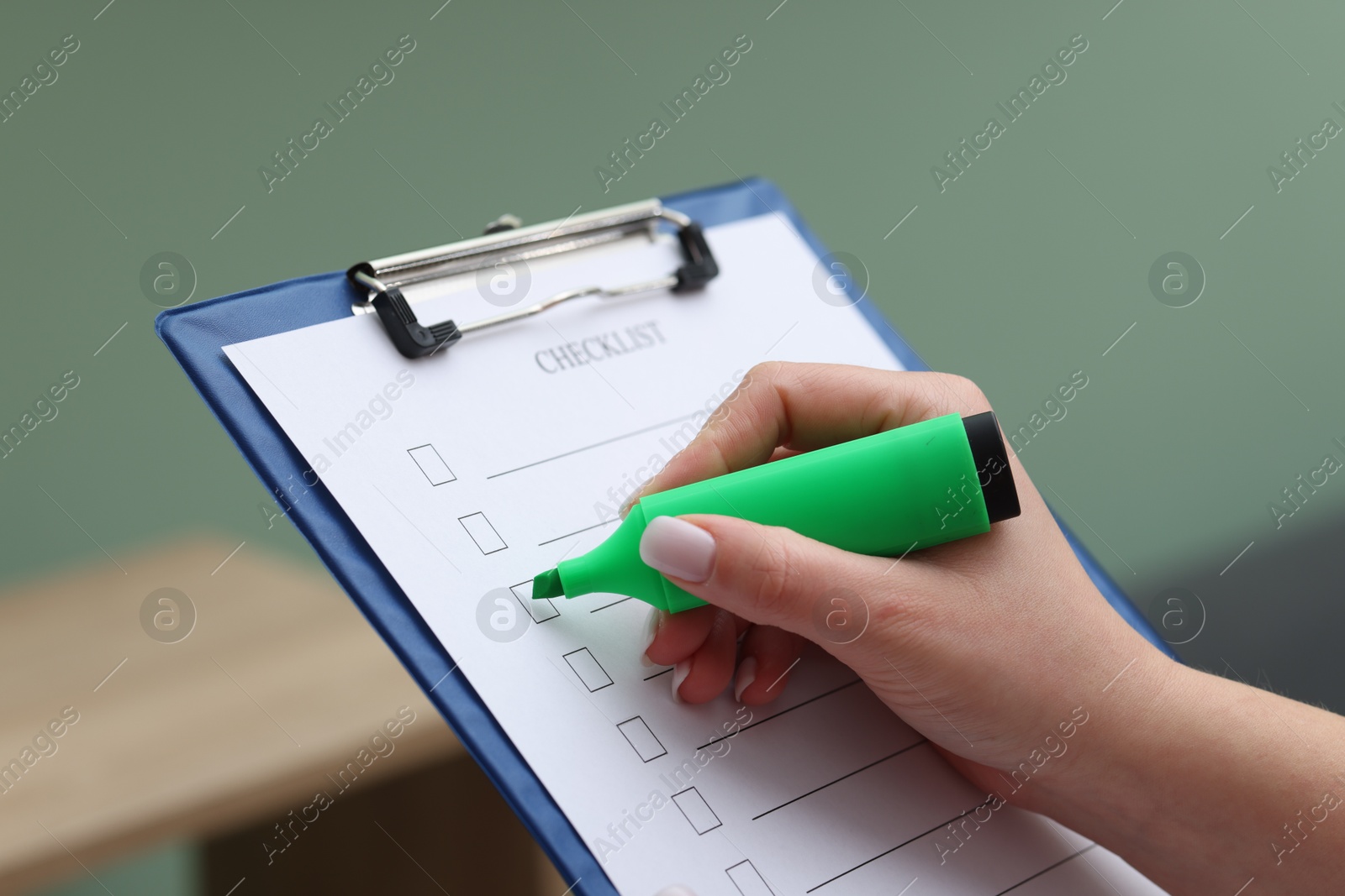 Photo of Woman checking box of checklist indoors, closeup