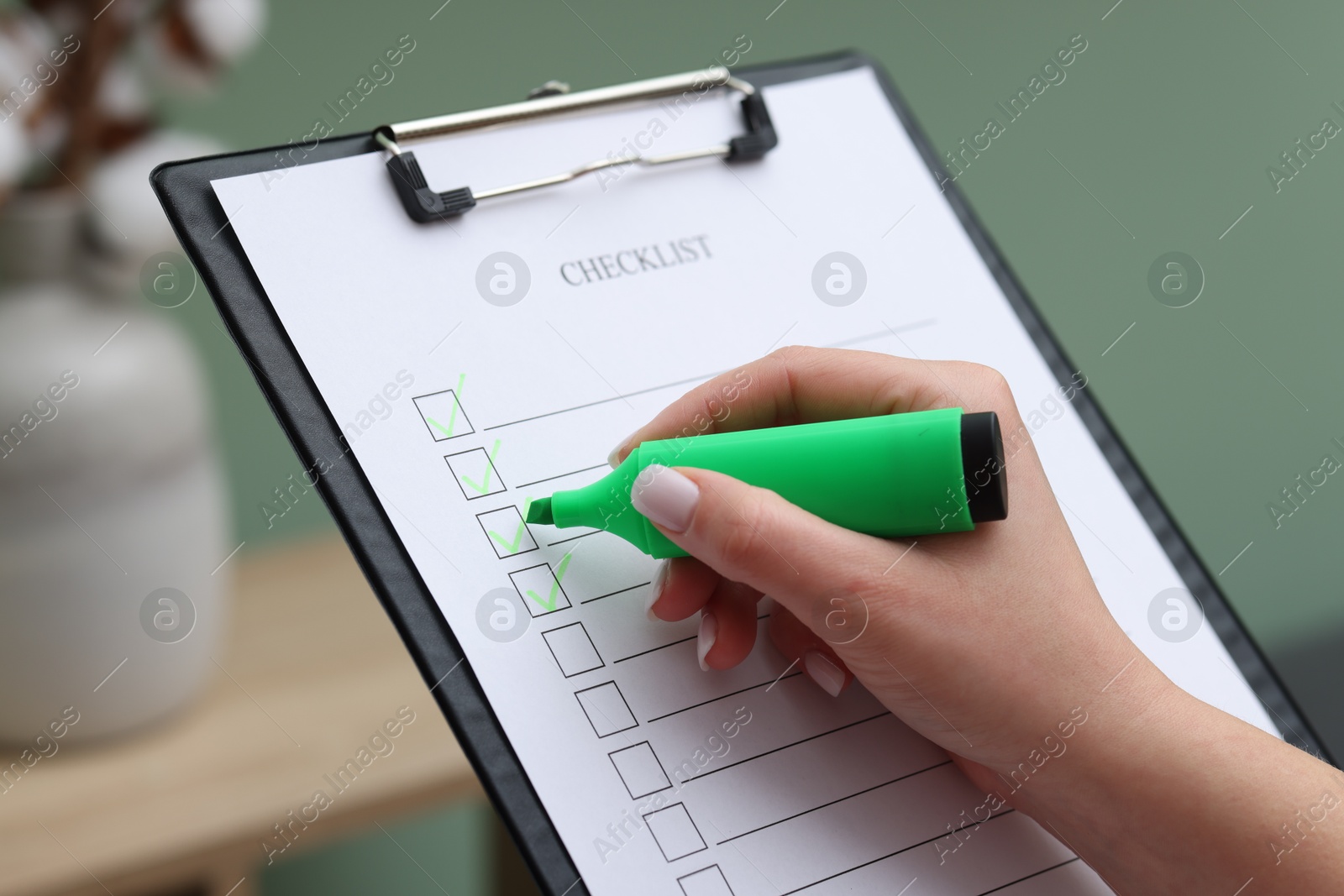 Photo of Woman checking box of checklist indoors, closeup