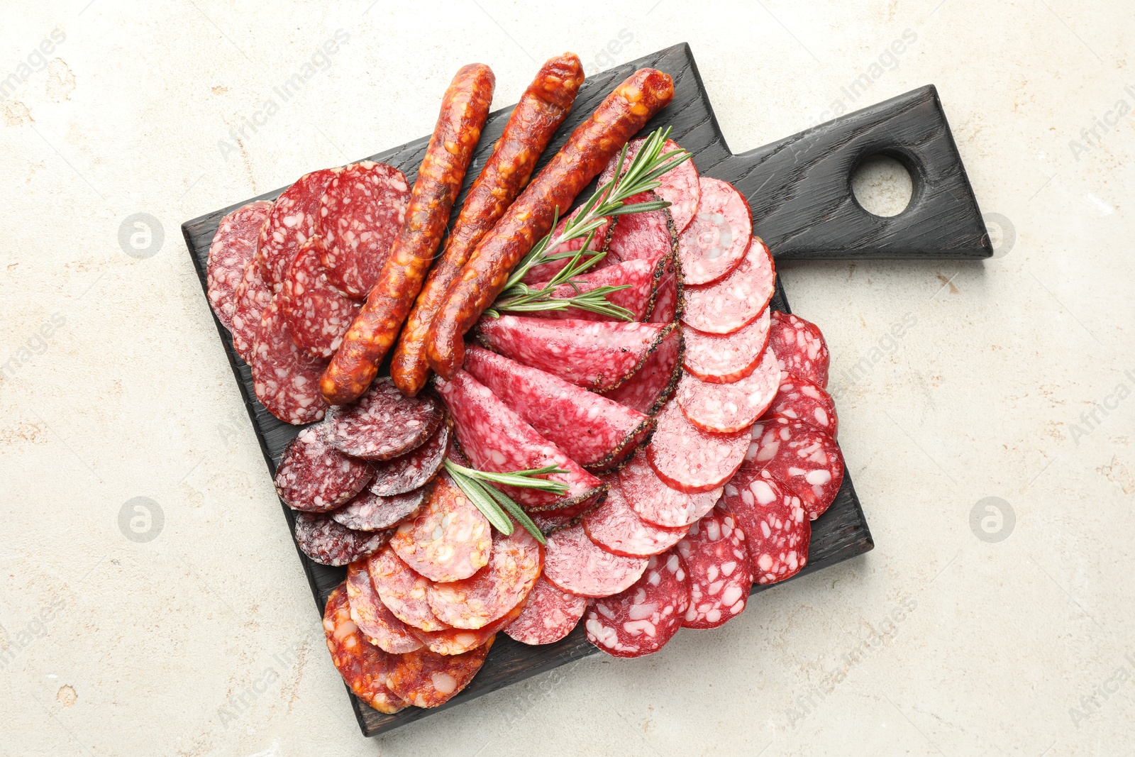 Photo of Different smoked sausages slices served on light table, top view