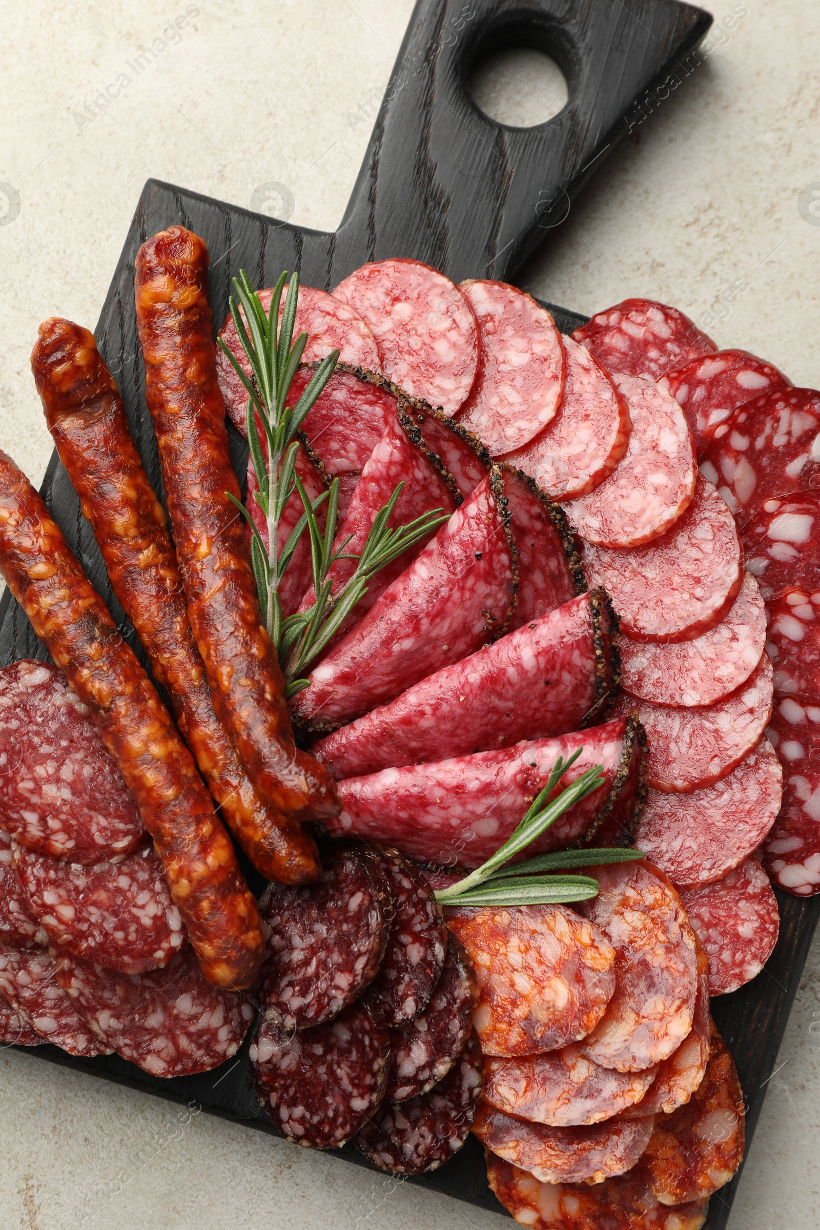 Photo of Different smoked sausages slices served on light table, top view