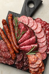 Photo of Different smoked sausages slices served on light table, top view