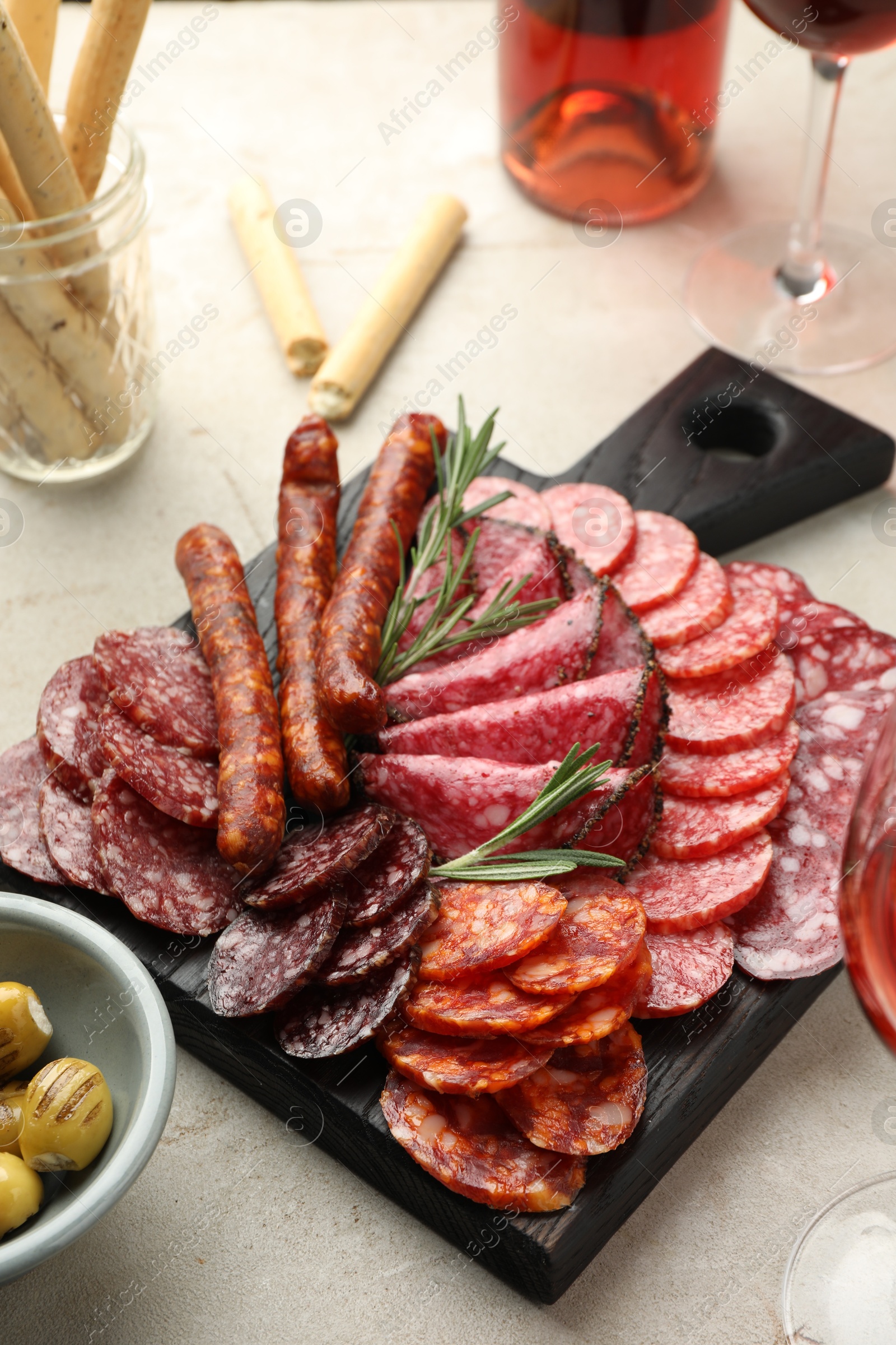 Photo of Different smoked sausages slices served on light table