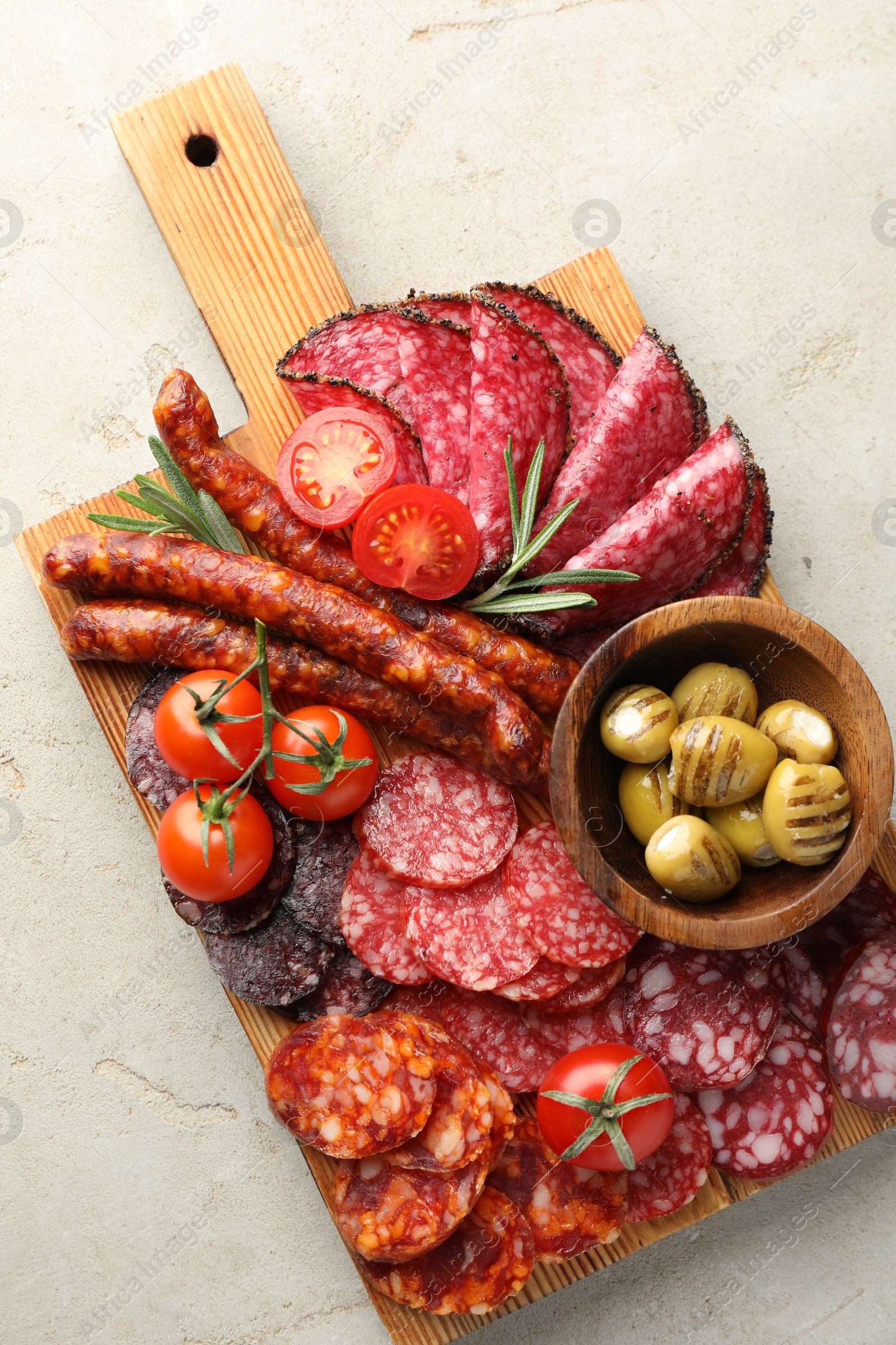 Photo of Different smoked sausages slices served on light table, top view