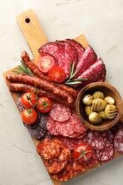 Photo of Different smoked sausages slices served on light table, top view