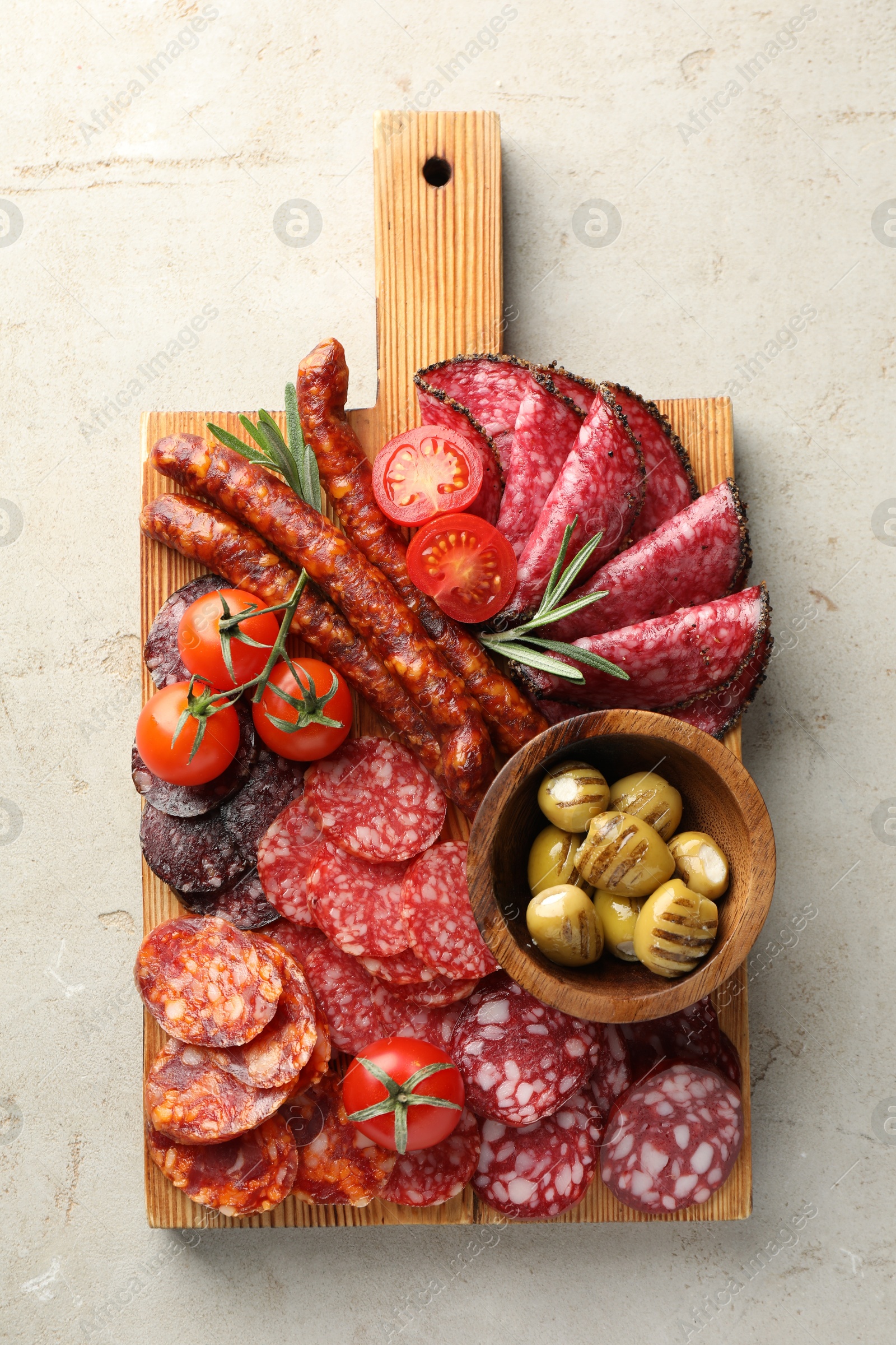 Photo of Different smoked sausages slices served on light table, top view