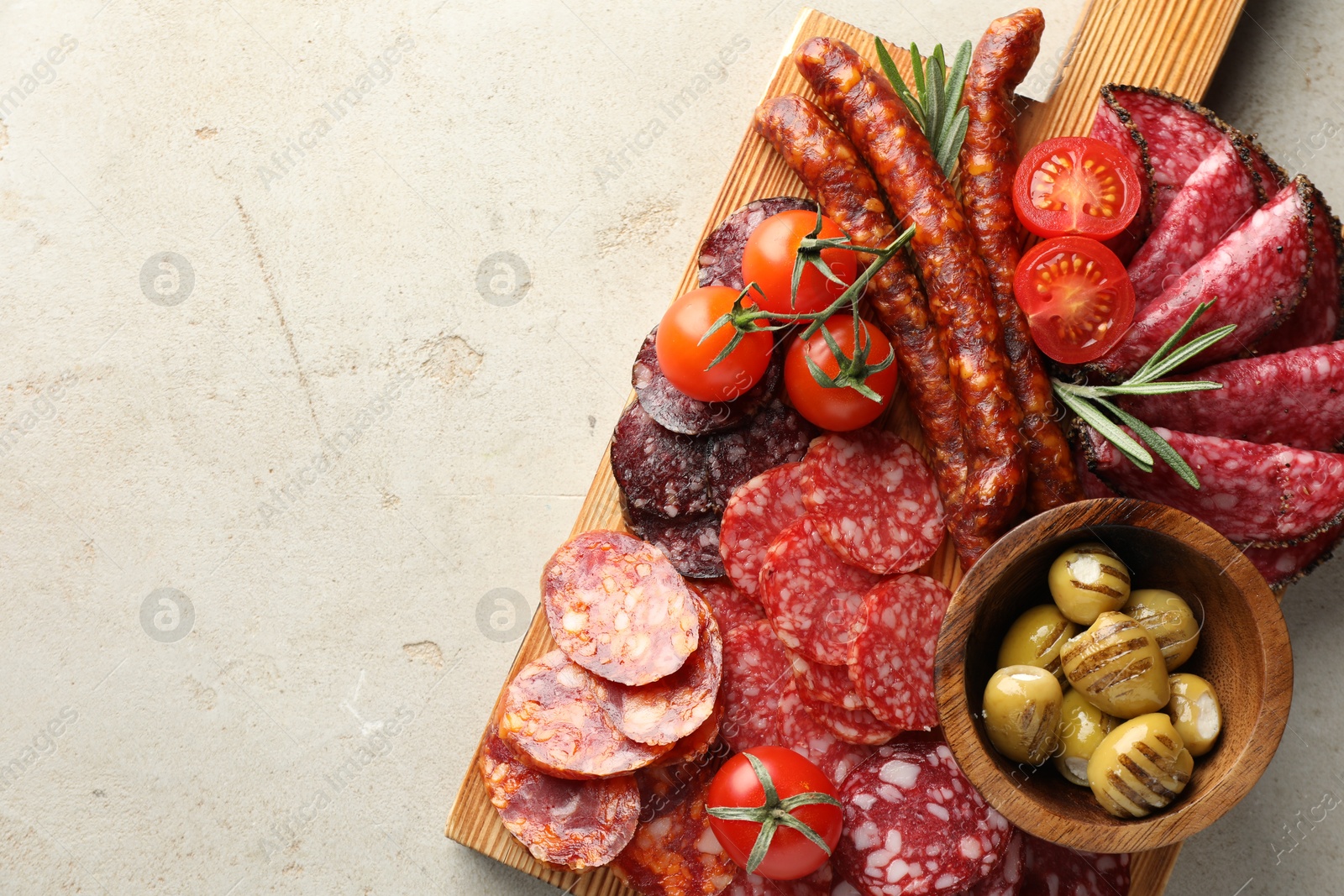 Photo of Different smoked sausages slices served on light table, top view. Space for text