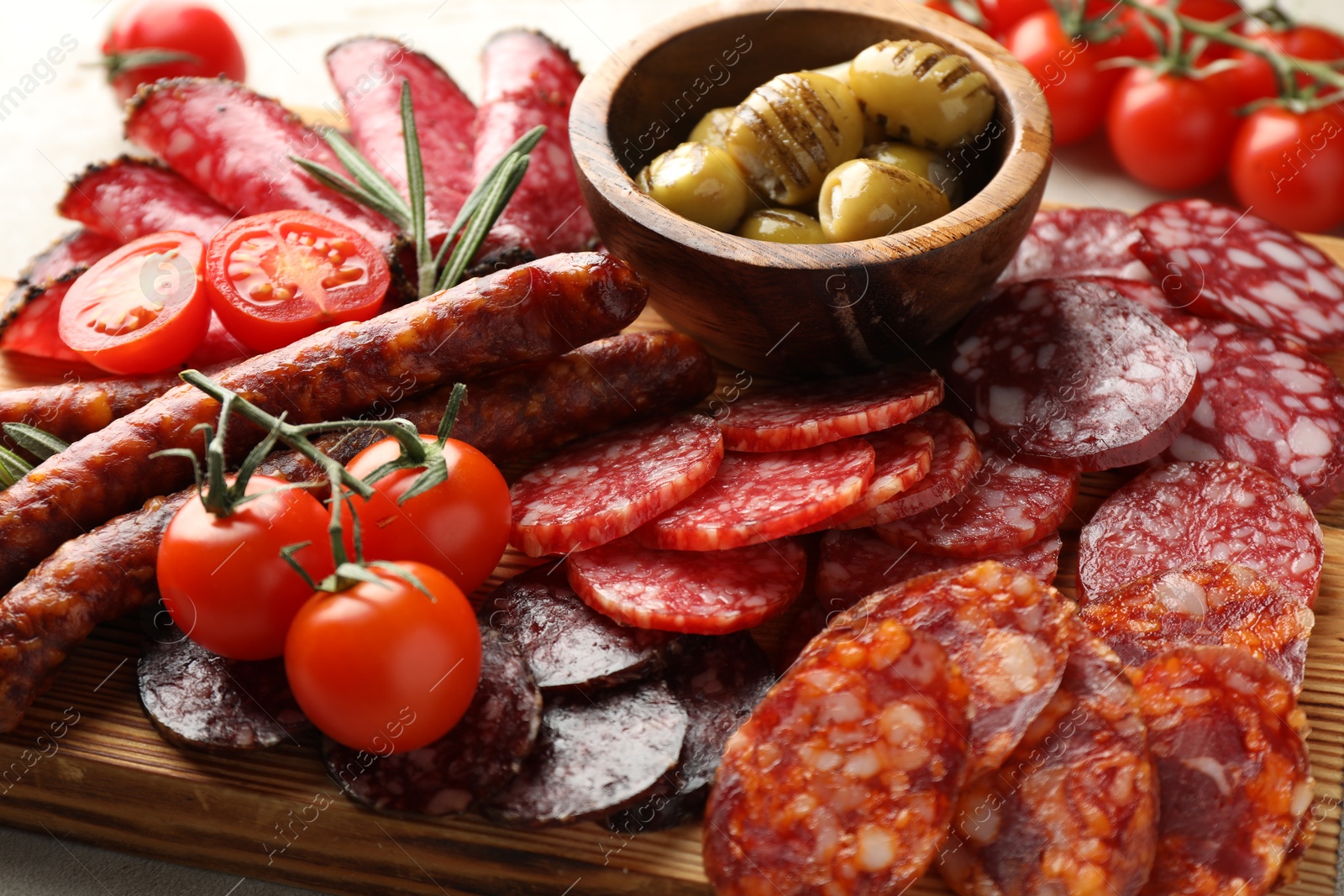 Photo of Different smoked sausages slices served on light table, closeup